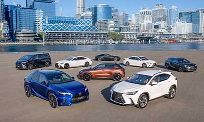Lexus Hybrid Range models in multiple colours with cityscape behind them.